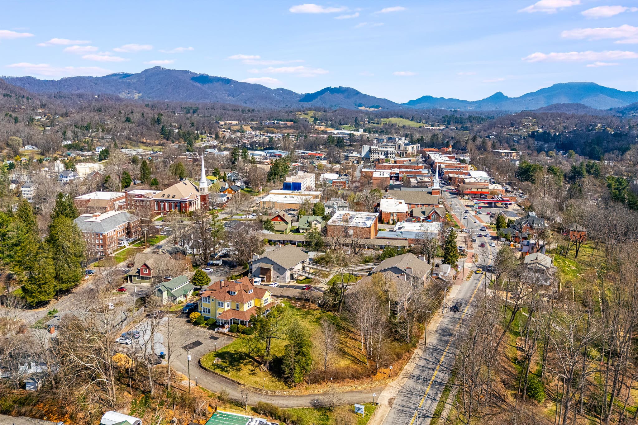 Ariel photo of downtown, mountains in the distance, large historic inn