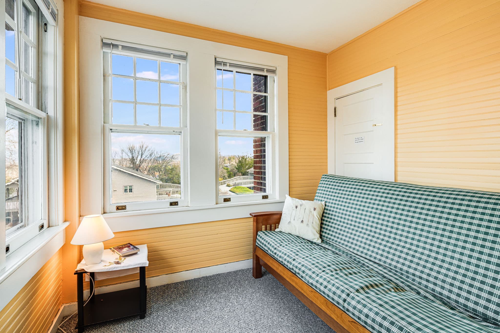 pull out sofa bed, pillow, four windows, side table, lamp