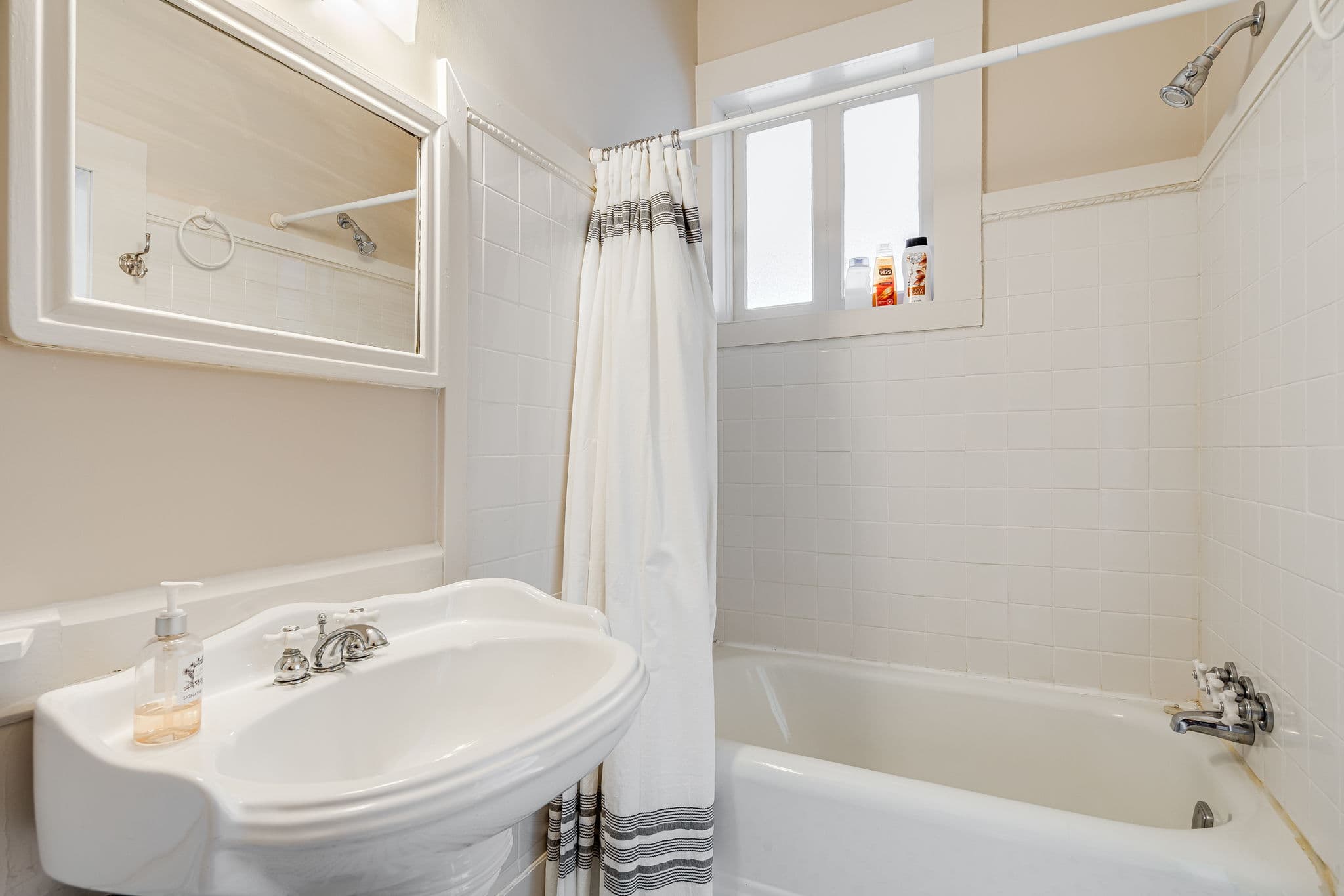 bathroom sink, mirror, tub, shower, window