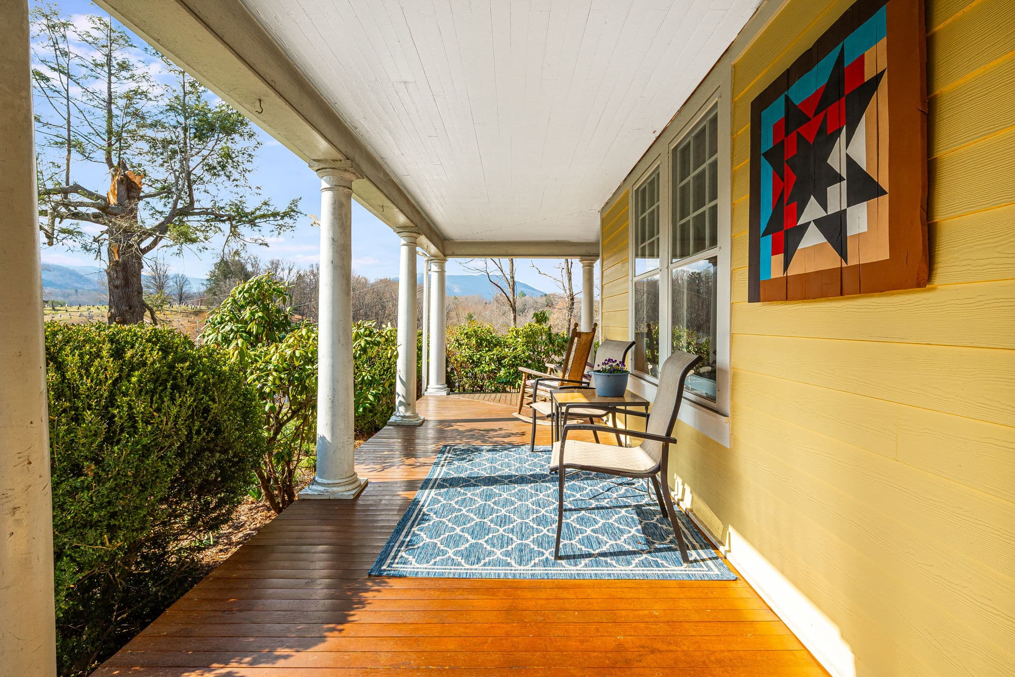 large porch with chairs on blue rug
